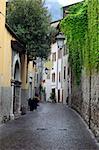 View of a narrow street in Arco, North Italy, with Alps in the background