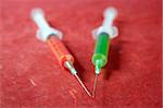 health still life red and green syringes over red background