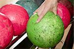 Bowling ball in player man hand in colorful rows