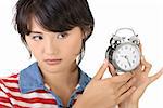 Woman holding alarm clock, closeup portrait of young girl of Asian on white background.
