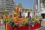 Buddhist shrine with Buddha statues, flowers and offerings