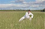 The young man practices Wushu in the field