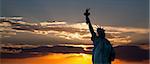 The silhouette of Statue of Liberty under sunrise background
