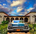 Front view in vintage american car parked in tropical residence, cuba