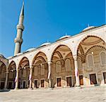 Inner courtyard with arches and minaret of the Sultanahmet Blue Mosque in Istanbul, Turkey