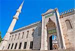 One of the entrance archways to the Sultanahmet Blue Mosque in Istanbul, Turkey with outer wall and minaret