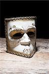 Carnival mask on vintage table, over black