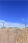 traditional rope fence over stone wall grunge cement blue sky