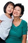Photo of Asian grandmother and granddaughter on white background.