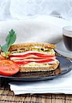 fresh and delicious classic club sandwich over a white glass dish with coffee