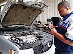 Auto mechanic performing a routine service inspection in a service garage.