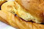 Background of different bread textures with loaves and bread rolls.