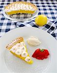 Delightful slice of lemon meringue pie with strawberries and cream.