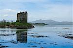 kayakers in sea canoes exploring castle stalker on small island in loch linnhe argyll in the scottish highlands
