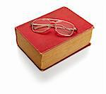 close up of an old book and eyeglasses on white background with clipping path