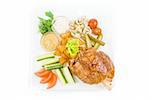 Tasty pork dish with vegetables on a white background