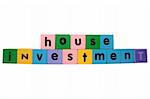 toy letters that spell house investment against a white background with clipping path