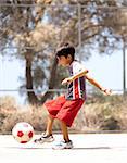 Young kid in action enjoying soccer, outdoors