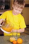 The child in a yellow vest drinks  orange juice