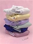 A stack of modern cloth nappies isolated against a pink background