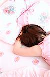 Young woman sleeping on bed in her bedroom at home in the morning.