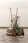 View of the stern of a fishing trawler on Pamlico Sound, North Carolina against a gray sky vertical