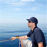 Sailor man sailing boat blue calm ocean water Mediterranean sea