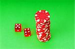 Casino chips and dice against green background