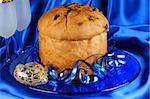 Italian Christmas composition with panettone and spumante over a blue background. Selective focus.