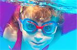 Underwater swimming girl goggles blue water portrait