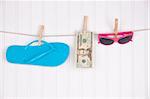 Fashion objects and money on a clothesline to represent the cost of summer fashion.