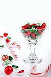 Christmas candies, canes and candy-corn in martini glass isolated on a white background