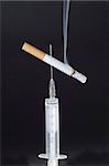 lighted cigarette on syringe needle concept