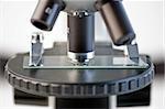 Close up of a microscope lens and stage platform