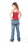 Cute young adult caucasian woman wearing a red top and jeans and with curly red hair on a white background. Not Isolated
