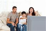Happy family watching a movie on television together on the sofa at home