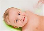 Beauty happy baby boy having bath with foam