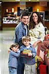 Happy family in shop with boxes of gifts