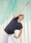 Young pregnant woman doing yoga exercises on sitting on the floor