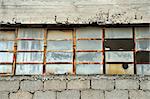 Old factory cinder block wall and broken windows.