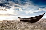 Old fisherman boat at sunrise time on the beach