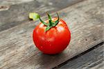 Fresh tomatoes with a leaf on a wooden table