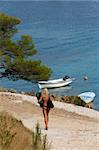 Typical Croatian beach, stones, magical blue water, and a beautifull, blond girl's perfect, round bottom in black mini bikini, without  the top of it.