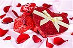 On a pink background gift box heart in the form of women's underwear, the background scattered rose petals.