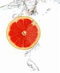 Fresh grapefruit dropped into water