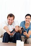 Excited man playing video games wth his girlfriend in the living room