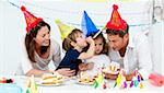 Happy family having fn while eating birthday cake in the kitchen