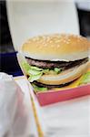 This photograph represent a double cheeseburger in a fast-food restaurant