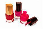 Three bottles of red nail polish isolated on white