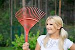 young pretty gardening woman with tools and rakes outdoors